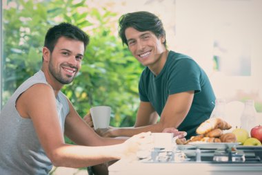 Genç gay çift kahvaltı mutfak güneşli bir günde var