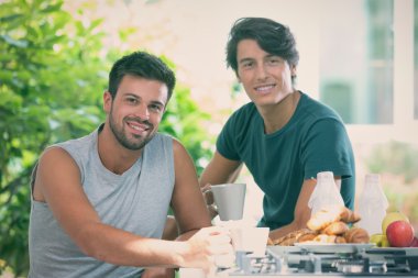 Genç gay çift kahvaltı mutfak güneşli bir günde var
