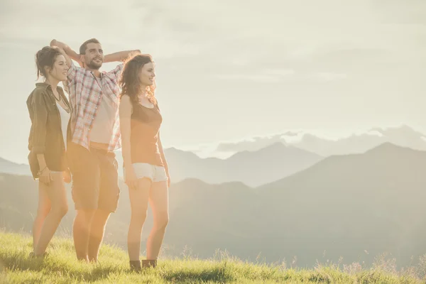 Three friends stand looking at panorama on mountain — Stock Photo, Image