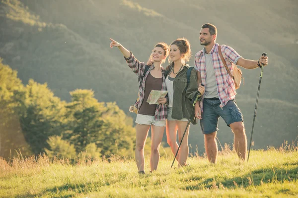 Três amigos ficam olhando o panorama na montanha — Fotografia de Stock