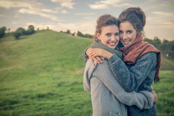 Young women looking at camera hug themselves in nature outdoor — Stock Photo, Image