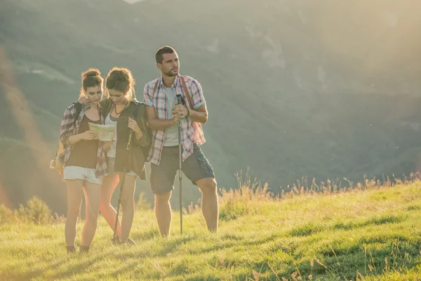 Three friends stand looking at panorama on mountain — Stock Photo, Image