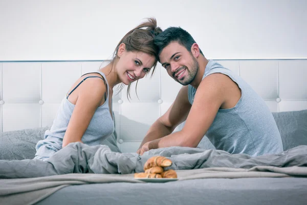 Jovem casal tomar café da manhã na cama pela manhã — Fotografia de Stock