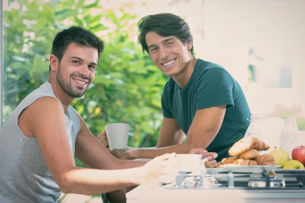 Young gay couple have breakfast in the kitchen in sunny day — Stock Photo, Image