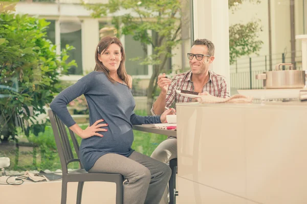 Expecting pregnant couple eating chocolate cake at home — Stock Photo, Image