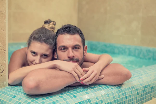 Jovem casal sorridente relaxante na banheira no spa — Fotografia de Stock