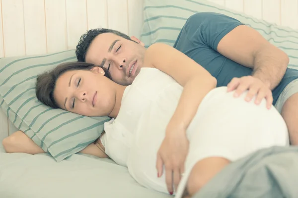 Embarazada morena mamá con marido yacía en la cama — Foto de Stock