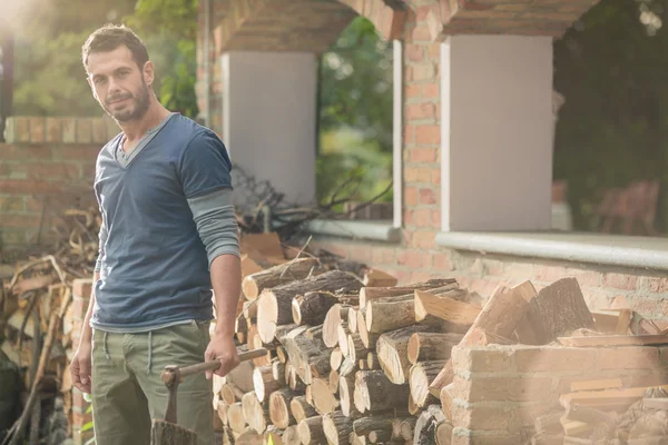 Jonge man zagen van hout in de tuin — Stockfoto