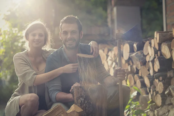 Young man cut wood with girlfriend in the garden — Stock Photo, Image