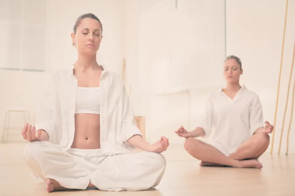 Twee blonde meisje doen yoga op sportschool — Stockfoto