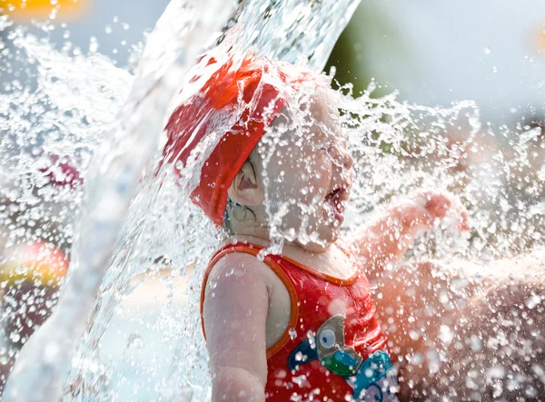 Aranyos boldog gyermek játszik a víz és buborékok, a nyári időszakban a medencénél — Stock Fotó