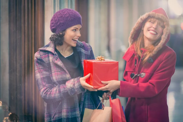 Жінки тримають різдвяний подарунок і сміються — стокове фото