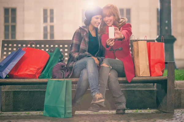 Mujeres tomando selfie mientras están sentadas en el banco — Foto de Stock