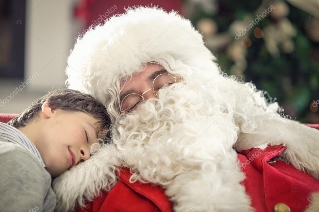 Santa Claus and boy sleeping on couch