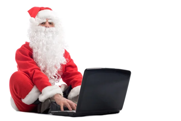 Santa claus sitting and using laptop — Stock Photo, Image