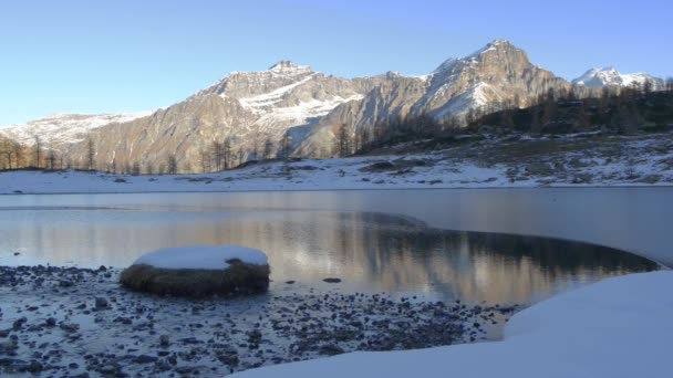 Rio de inverno que flui para lago de montanha congelado — Vídeo de Stock