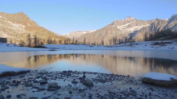 Río de invierno que fluye a lago de montaña congelado — Vídeo de stock