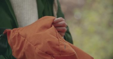 Genç bir kadın çantasından bir günlük kitabı çıkarıyor ve sonbaharda bir salıncakta kollarında sıkıca tutuyor. yavaş çekim