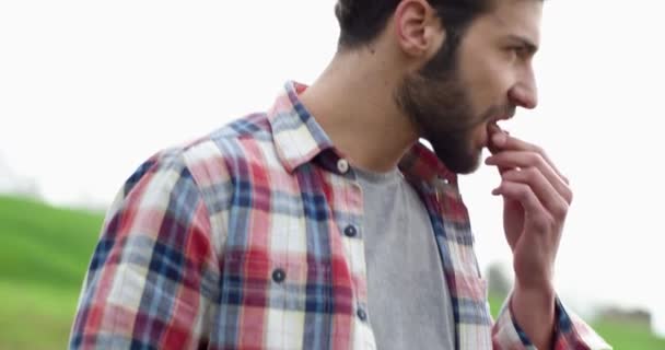 Close-up van de hand van een man die eten eet tijdens een camping in de herfst. Eten geven aan zijn hond. — Stockvideo