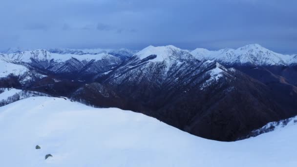 Montaña nevada con cresta de montaña en frente revelando cordillera cubierta de nieve después de nevadas en otoño. cámara lenta — Vídeo de stock