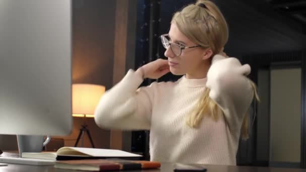 Mujer joven moviendo el cabello en un lado, mirando la computadora en casa u oficina.Aprendizaje remoto o trabajo a distancia.Mujer trabajando, bebiendo una taza de café durante la noche en casa — Vídeos de Stock