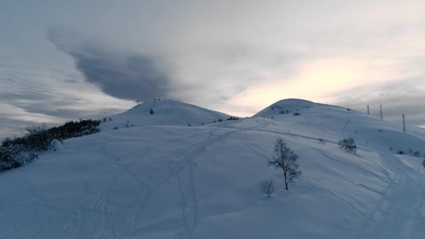 日没の間の冬の雪の空中ビューの山の範囲の風景キャップ。山側の暗い木の森。スローモーション — ストック動画