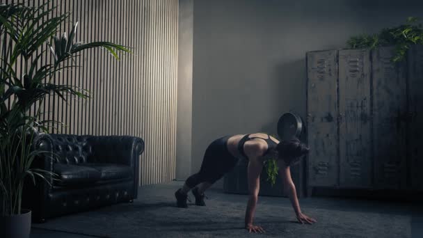 Femme brune sportive et belle faisant des pompes d'épaule dans les vêtements de sport à la maison. Mouvement lent — Video