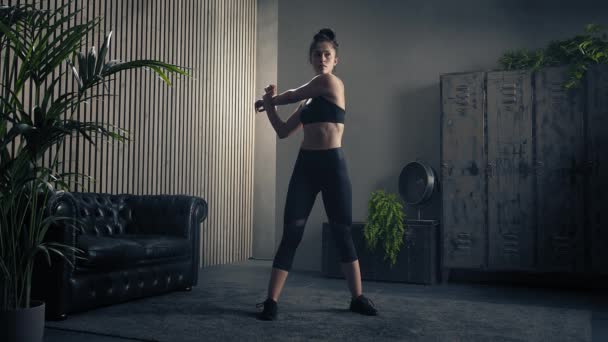 Svedig og træt sporty brunette kvinde strækker sig efter intens træning derhjemme. Langsom bevægelse – Stock-video