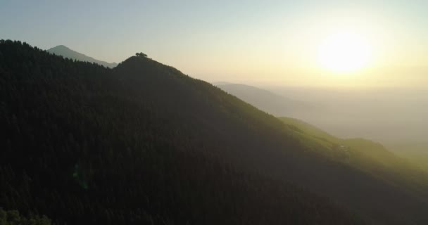 Прекрасний вид на гори з безпілотника. Літаючий безпілотник над лісами серед гір під час заходу сонця. Красиві сонячні промені на горах і відтінок від горизонту . — стокове відео