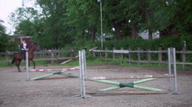 At binme dersi sırasında çiftlikte kahverengi ata binen bir kadın..