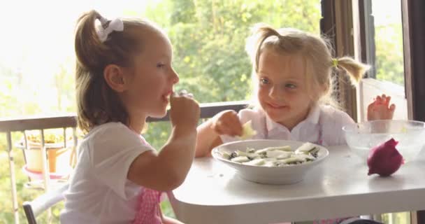 Two beautiful girls cooking cookies during morning light. family cooking, two kids learning by grandma mixing ingredients.Domestic life, family hobbies — Stock Video