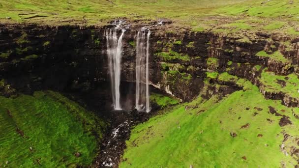 Luftaufnahme eines atemberaubenden Wasserfalls auf den Färöern. Luftaufnahme des Fossa-Wasserfalls. Bewölktes Wetter, Einspielergebnis, keine Menschen. Majestätischer Wasserfall in wildem Felshang. Hochwertiges Filmmaterial. — Stockvideo