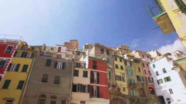 Liguria, İtalya 'daki Cinque Terre sahilinin yavaş çekimleri. Deniz, karakteristik renkli bina, deniz kenarında uzanan insanlar.