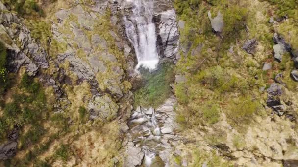 Veduta aerea della cascata che scorre attraverso rocce di montagna. Su entrambi i lati foresta verde — Video Stock