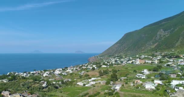 Vista aerea panoramica della costa di Salina, estate e giornata di sole. Tipiche case bianche i entroterra, mare blu sul lato e montagna verde sullo sfondo — Video Stock