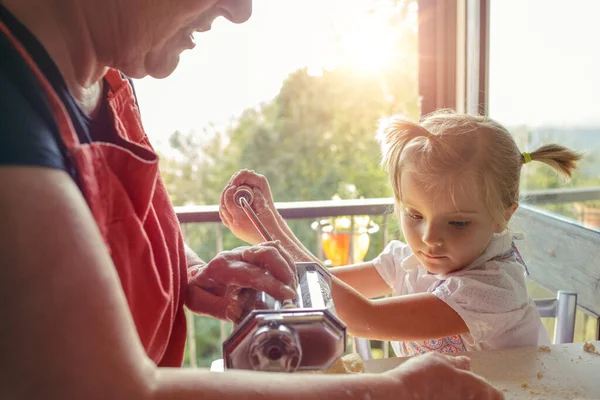 İki yeğeni olan büyük anne makarna yapıyor. Eski ve yeni nesil. Geleneksel değer nesilden nesile geçti. Aile kavramı, insani değer. yavaş çekim — Stok fotoğraf