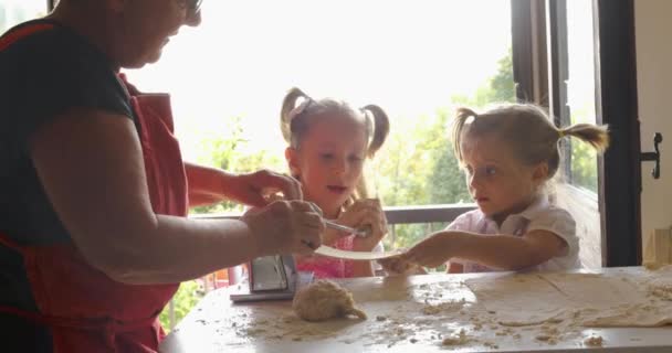 Abuela con dos sobrinos cocinando pasta. Vieja y nueva generación. El valor tradicional pasa de generación en generación. Concepto familiar, valor humano. cámara lenta — Vídeos de Stock