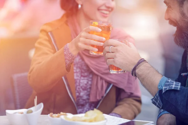 Cuplu fericit iubitor care se bucură în aer liber bar cafenea, restaurant.Love, dating, alimente, stil de viață.Prieten și prietenă care stau într-un bar, bea aperitiv spritz, face un toast într-un centru istoric Fotografie de stoc