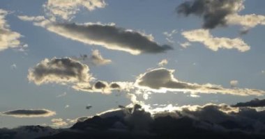 Güzel ve renkli dağ günbatımının zaman geçişi. Bir yaz akşamında güneşin batışıyla gökyüzünde hareket eden bulutların zaman akışı. Seyahat, doğa konsepti.