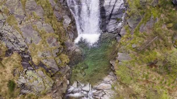 Vue aérienne de la cascade coulant à travers les rochers de montagne. De chaque côté forêt verte — Video