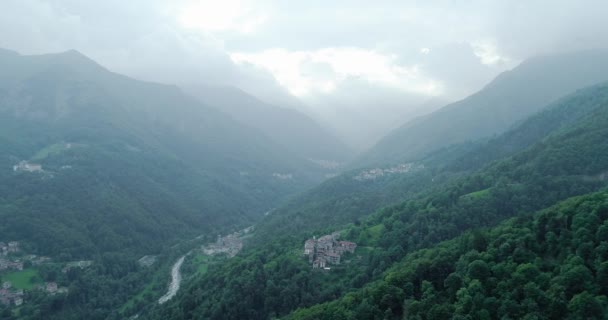 Luchtfoto van de groene vallei. Rivier oversteken berg. Wolken bergketen op de achtergrond. — Stockvideo