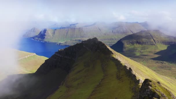 Drone vliegt door wolken. Luchtfoto van groen gras bergketen, in de achtergrond blauwe zee en majestueuze landschap. achtergronden. Onberispelijke natuur — Stockvideo