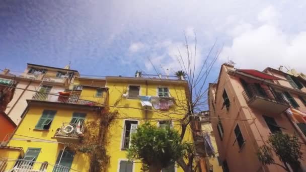 Cinque Terre, atrakcja turystyczna. Zabytkowe i kolorowe budynki wzdłuż ulicy, błękitne niebo w letni słoneczny dzień. — Wideo stockowe