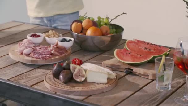 Afwisselend aperitief met vleeswaren, vers fruit, dranken, kaas. Vriendengroep die plezier hebben en buiten snacks eten van de aperitieftafel. Italiaans buffet — Stockvideo