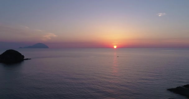 Flygfoto över en färgstark solnedgång över havet, Eoliska öarna. Reflekterad sol på en vattenyta. Lila, röd, blå, orange skymning. Silhuett av öar i en sommarsolnedgång. Långsamma rörelser — Stockvideo