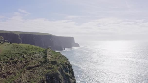 Des images en 4k des falaises de Mère en Irlande. Lieu célèbre irlandais. Mer agitée, vent, mouettes, journée ensoleillée — Video