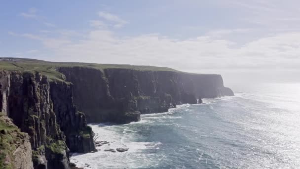 Beelden in 4k van de kliffen van Moeder in Ierland. Ierse beroemde plek. Ruwe zee, wind, meeuwen, zonnige dag — Stockvideo