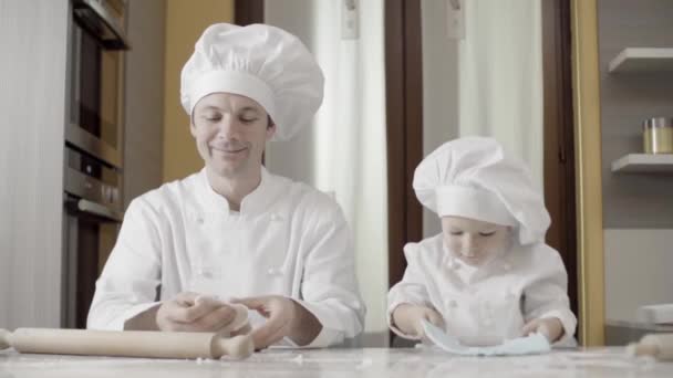 Tata şi fiul au făcut pastă albastră de zahăr în bucătăria lor. Momente de tată și fiu în timp ce gătesc. Tata învață fiul gătit un tort acasă . — Videoclip de stoc