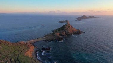 Deniz batımında, Dağ Kayalık Tepesi 'ndeki hava manzaralı deniz feneri. Gün doğumunun inanılmaz görüntüleri. Renkli günbatımında, kayalık adada, gün batımında kayalık deniz fenerinde.