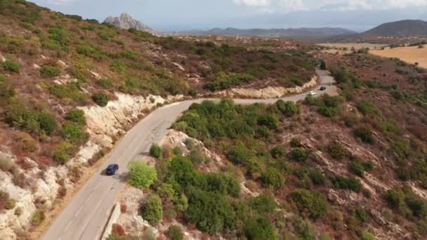 山の風景への日当たりの良い道路の高速道路を走行する電気自動車の空中ショット。 — ストック動画